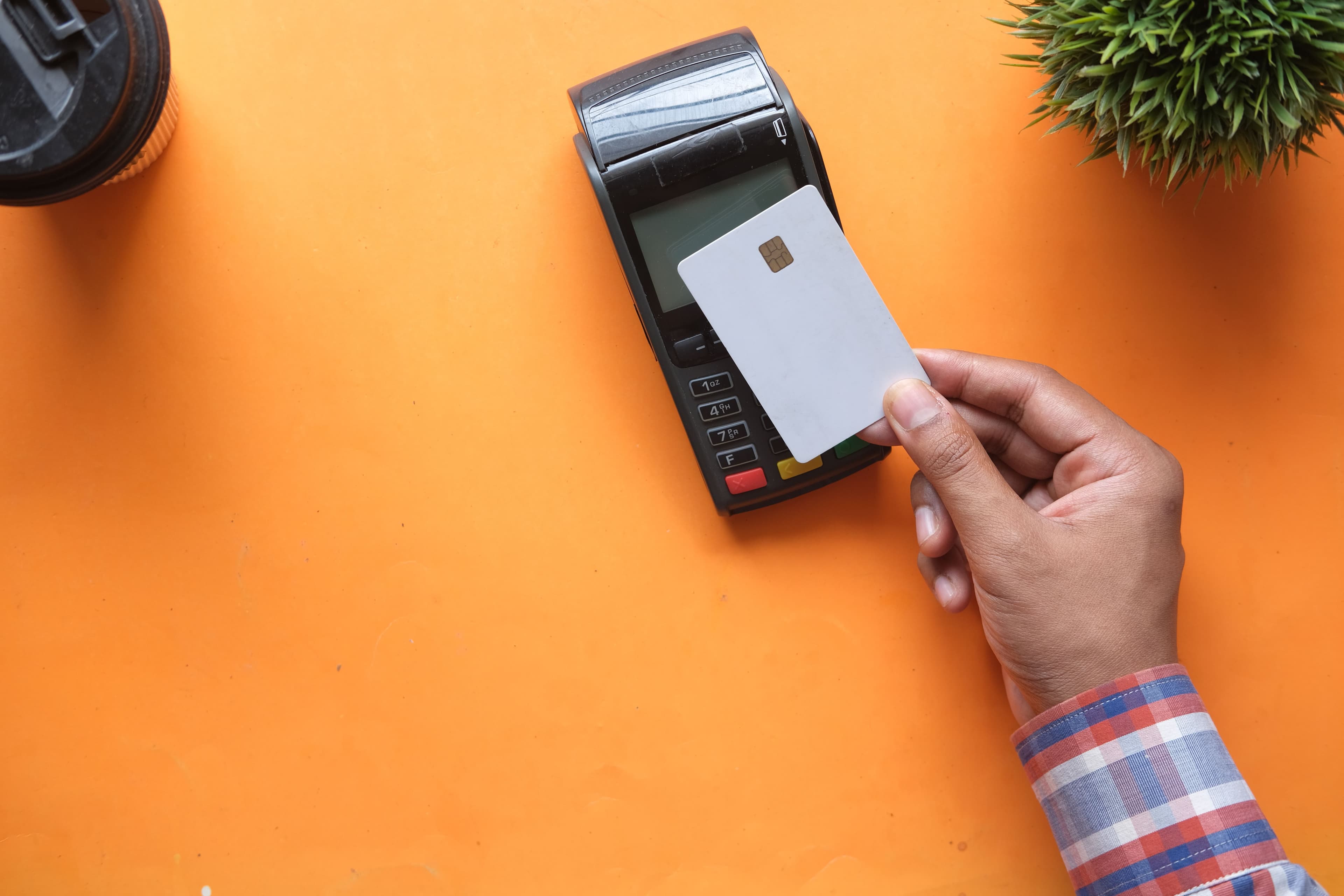 Mão a efetuar um pagamento por cartão sem contacto num terminal, representando o uso quotidiano de um cartão pré-pago