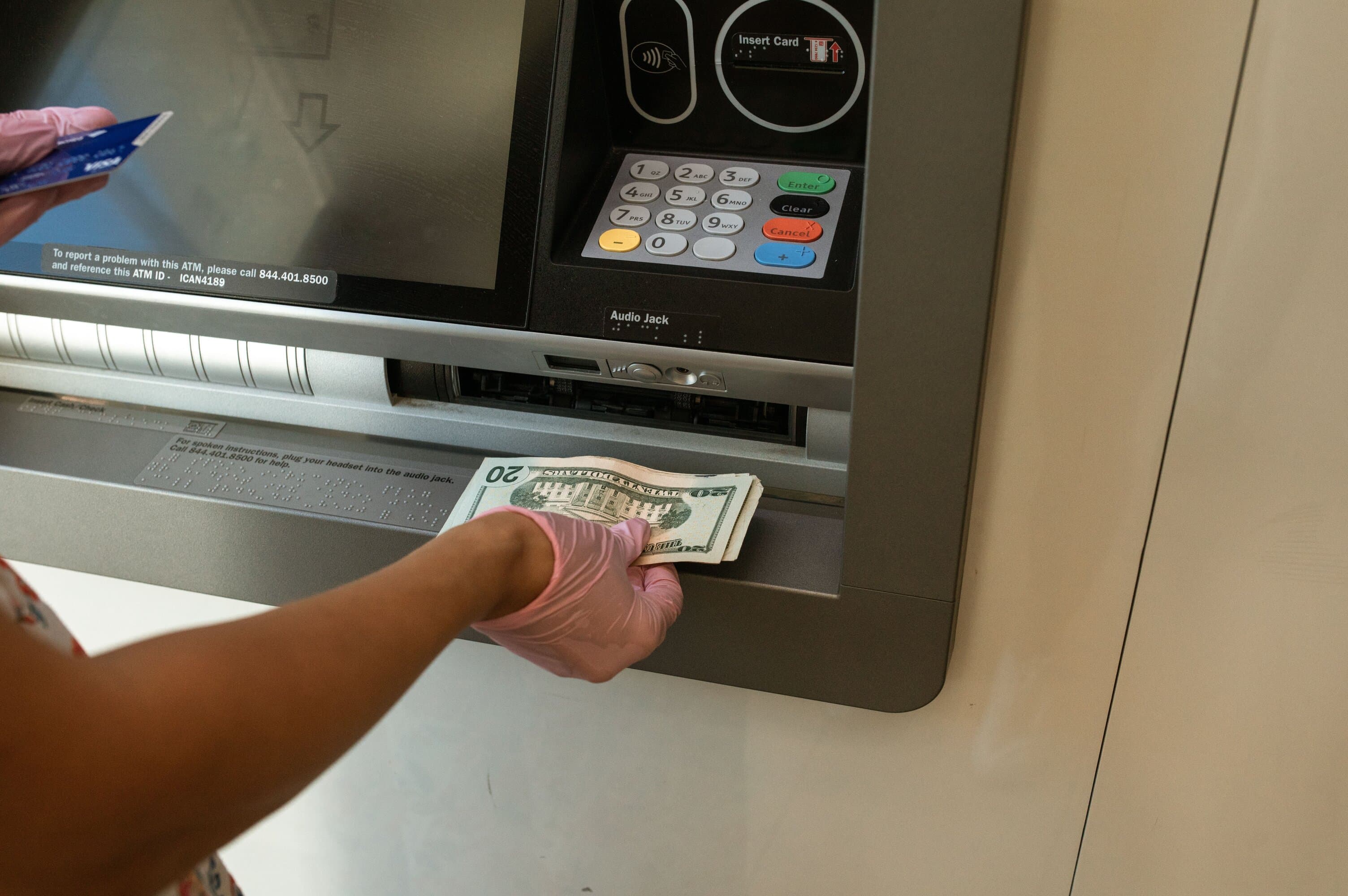 A person withdrawing cash from an ATM abroad